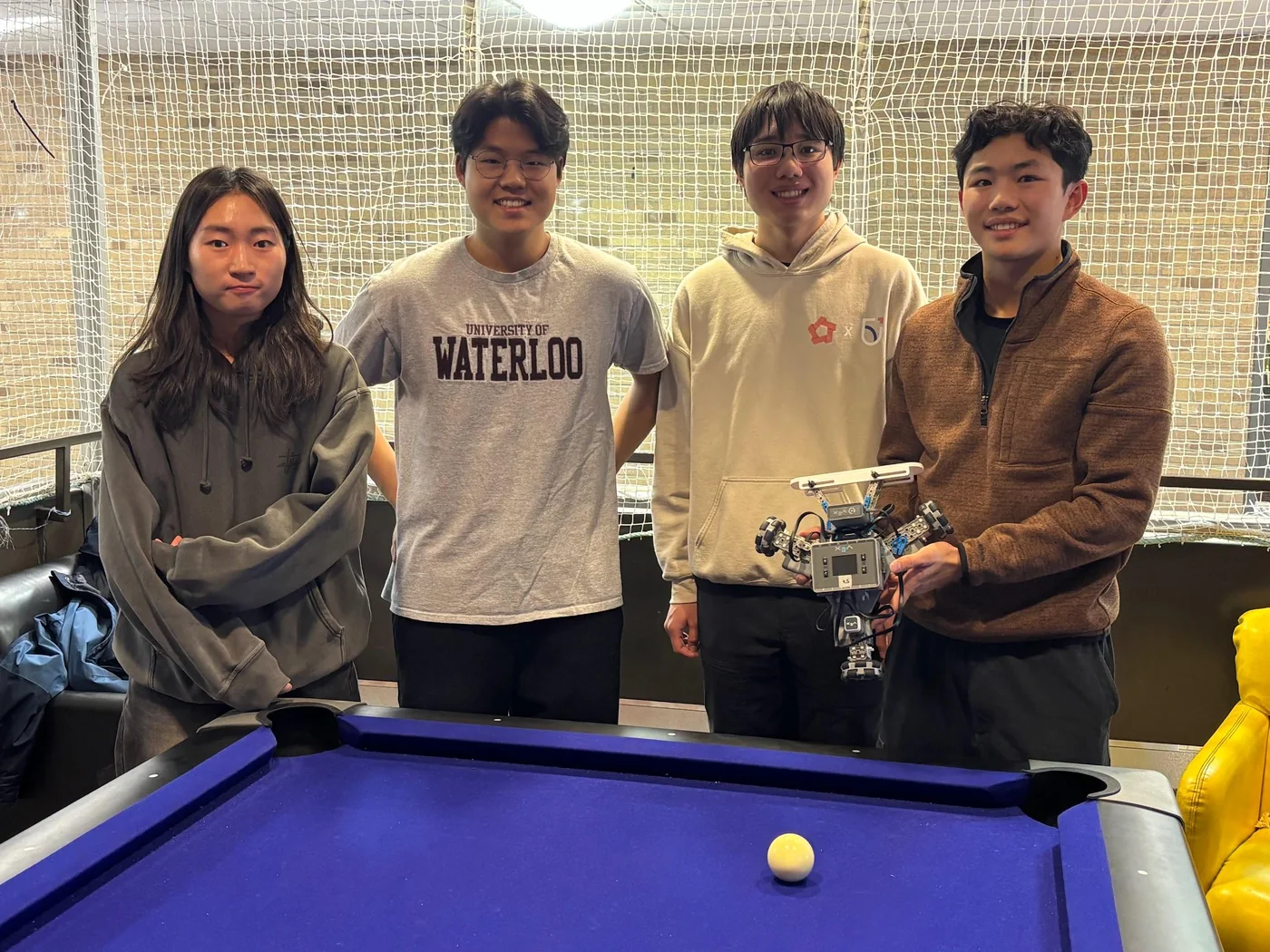 The project team with the robot at the pool table